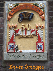 716542 Fotopaneeltje, met een afbeelding van de gevelsteen '50 jaar Buurtvereniging Margriet in de Zeven Steegjes, ...